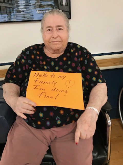 Resident holding a sign for their family during COVID-19