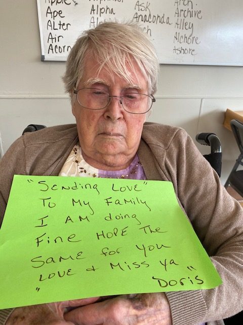 Resident holding a sign for her family