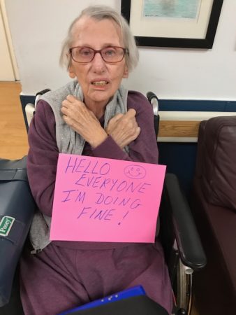 Resident holding a sign for her family