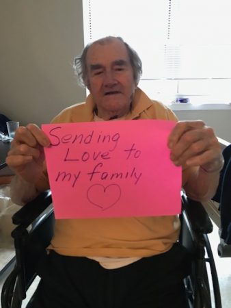 Resident holding a sign for his family