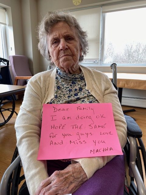 Resident holding a sign for their family