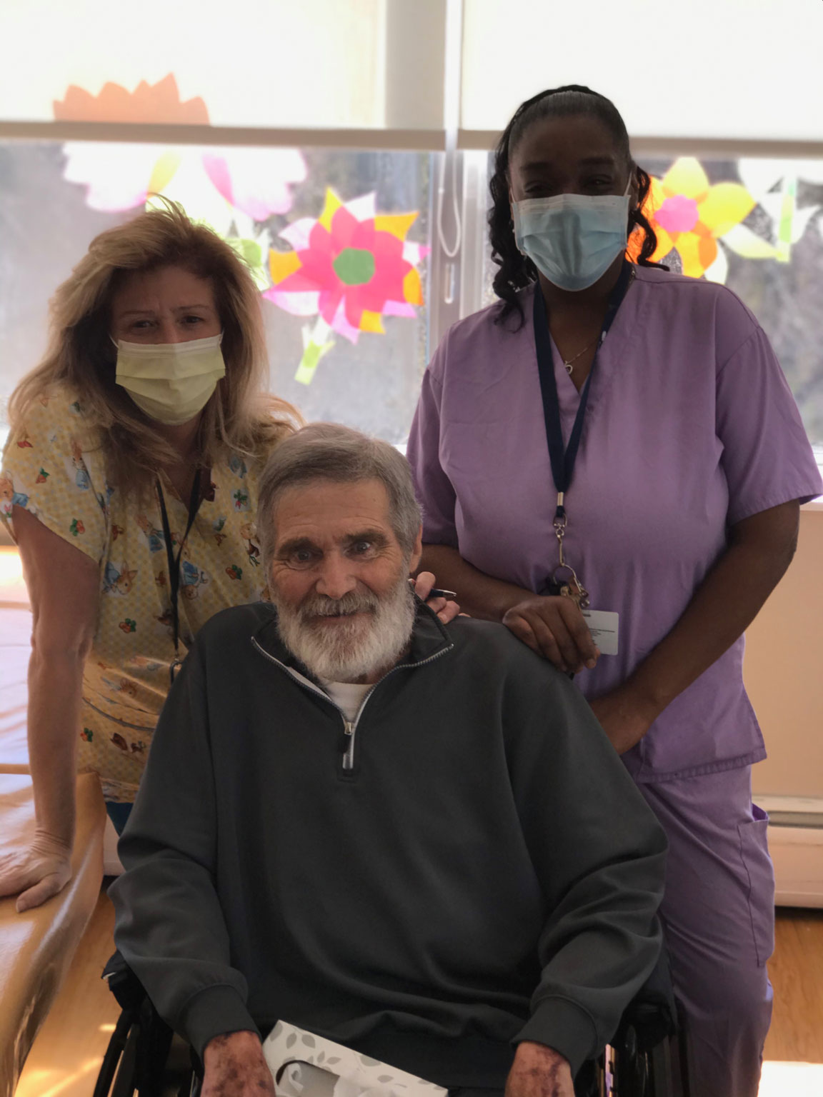 Two nurses posing with a male resident