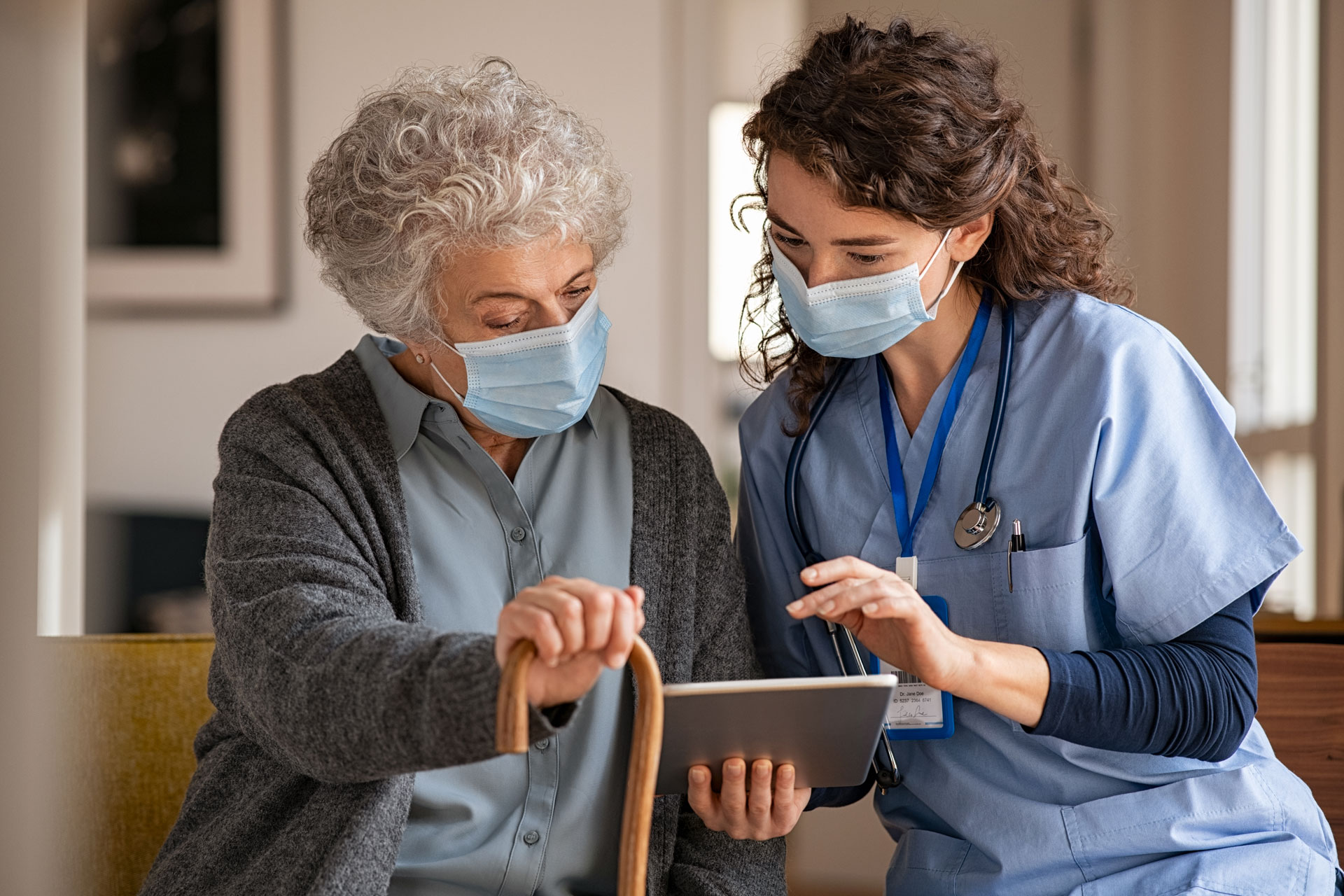 nurse meeting with nursing home resident wearing masks