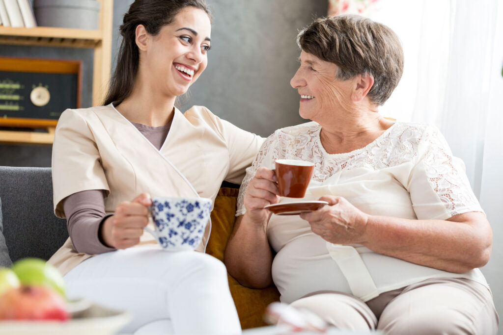 nursing home volunteer having coffee with a resident