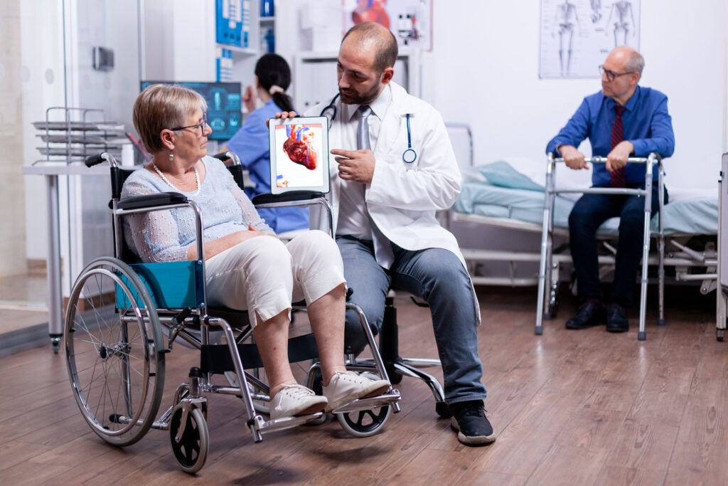 doctor explaining heart disease to female senior in wheelchair