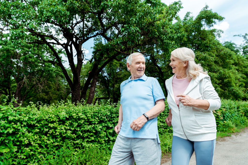 male and female seniors briskly walking in a park