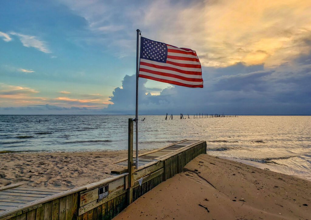American flag on a beach at sunset