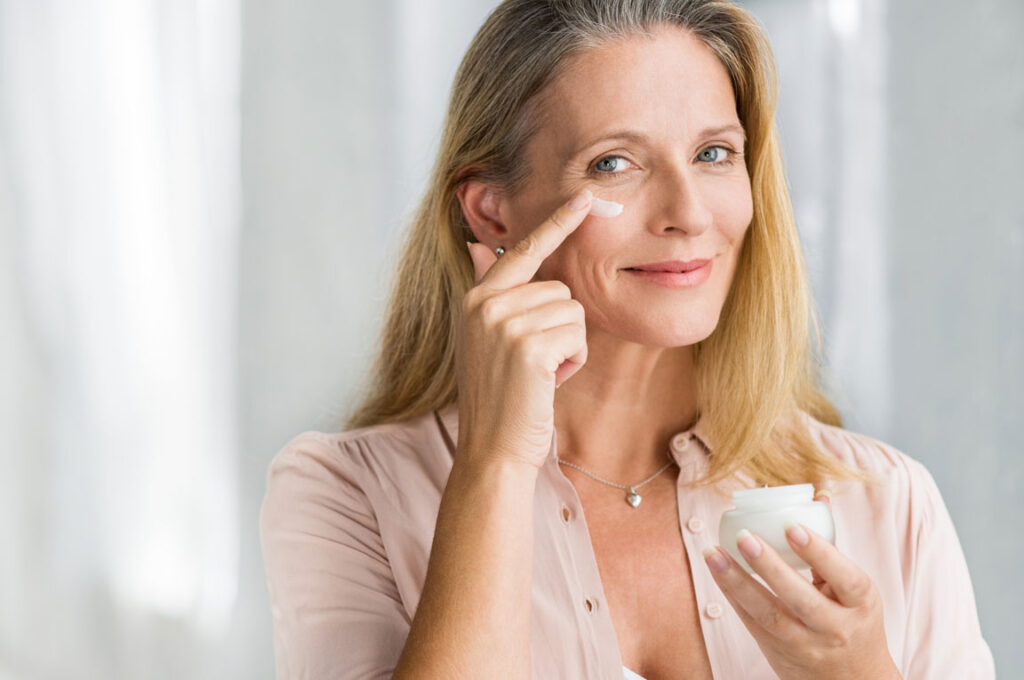 older woman applying skin cream