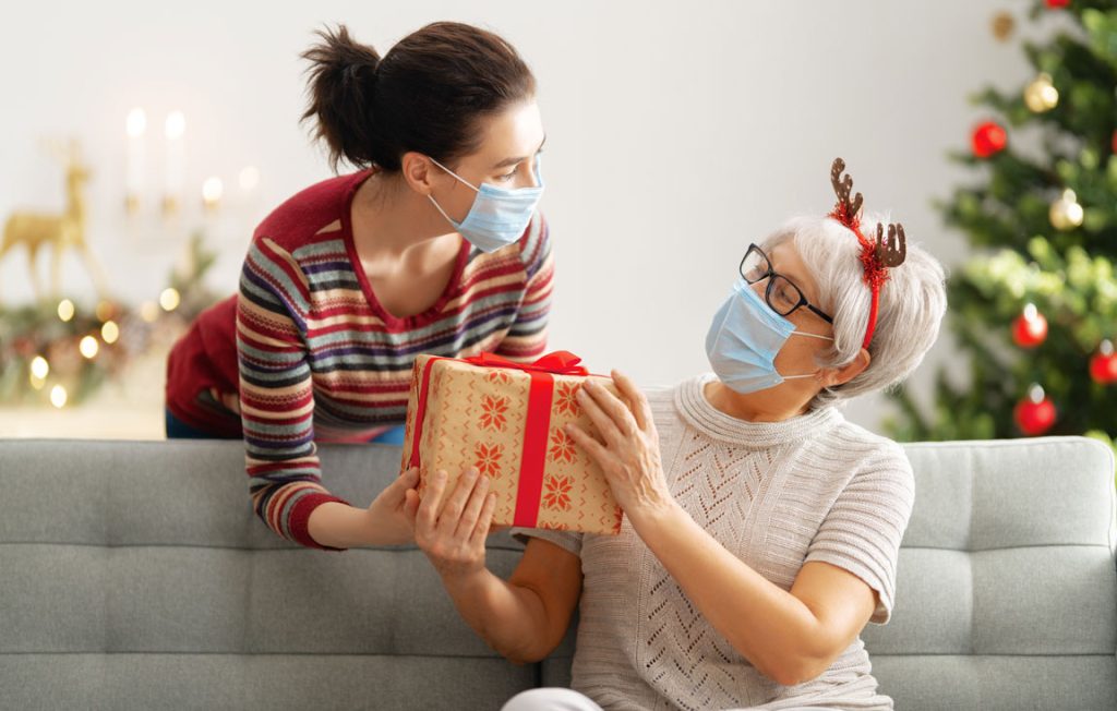 mother and daughter celebrating Christmas wearing protective face masks