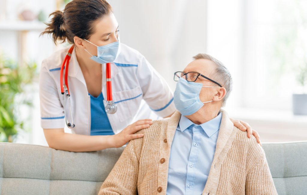 nursing home resident and nurse wearing face masks