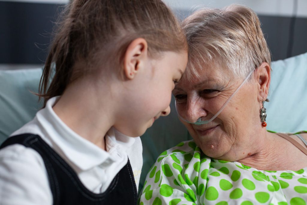 grandmother being visited by granddaughter during palliative care