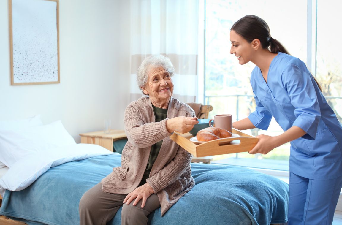 female nurse giving older woman a tray