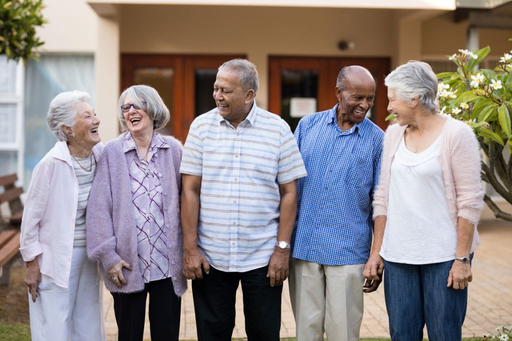seniors laughing outside of a nursing home