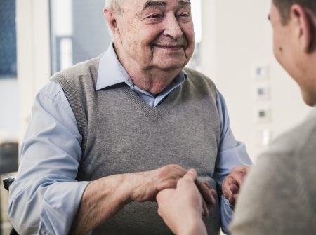 Older man holding hands with younger man