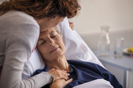 Woman kissing older woman on the forehead